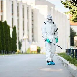 Profesional en traje de protección desinfectando las calles de la ciudad durante la pandemia del coronavirus