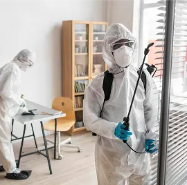 Personas con equipo de protección para desinfectar un área peligrosa